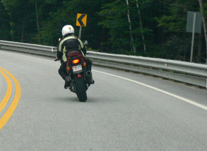 Look, Slow, Lean and Accelerate. Note the lower guardrail installed to make the guardrail less lethal to crashing riders.